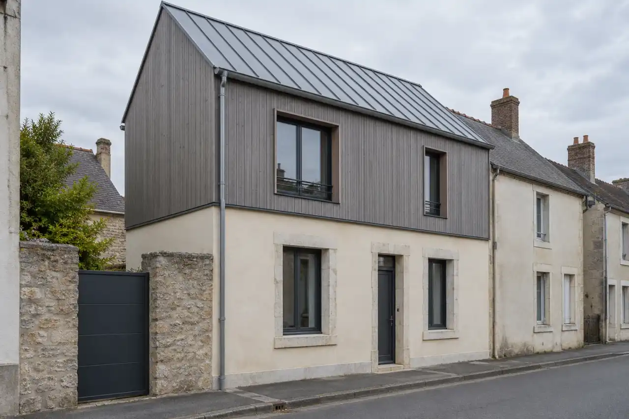 Maison de ville surélevée d’un étage en ossature bois habillée de bardage gris, toiture en zinc